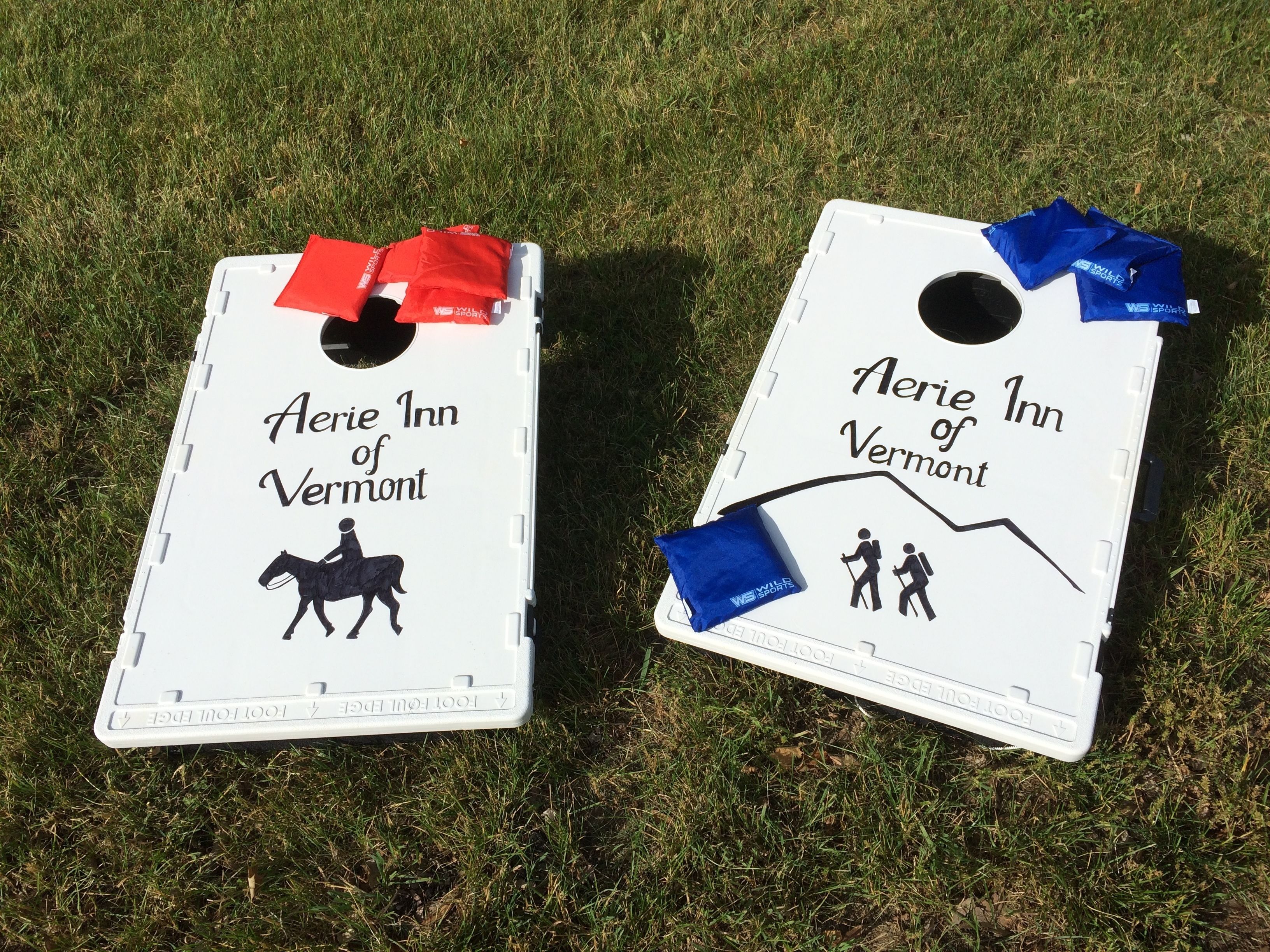 Deux panneaux blancs sur lesquels on peut lire « Aerie Inn of Vermont » et qui présentent des illustrations d’un cheval et de personnes en randonnée.