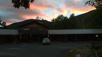 A rustic lodge with a large wooden building and a car parked in front.