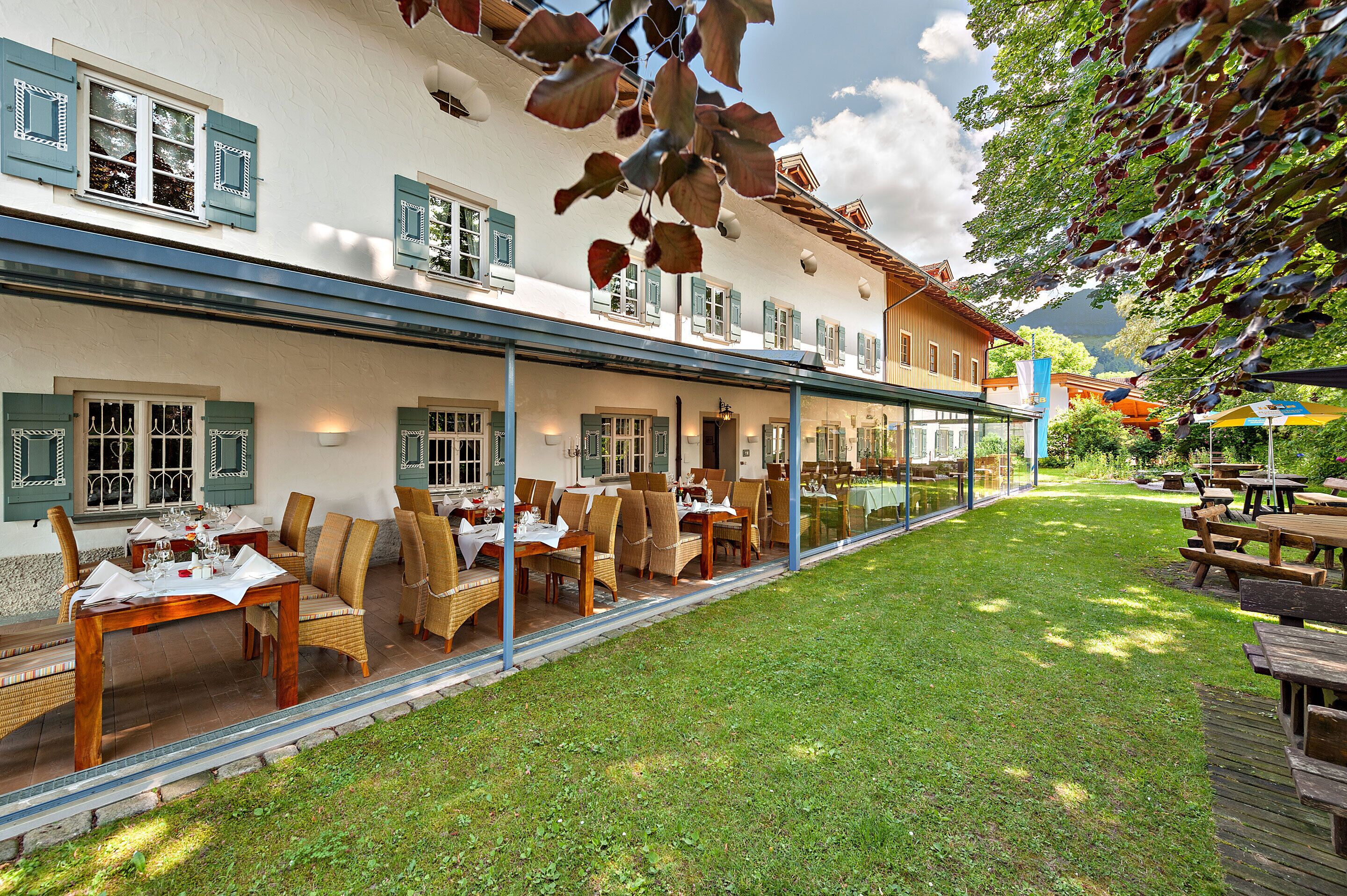 A hotel with outdoor dining, a covered patio, and a view of the surrounding landscape.