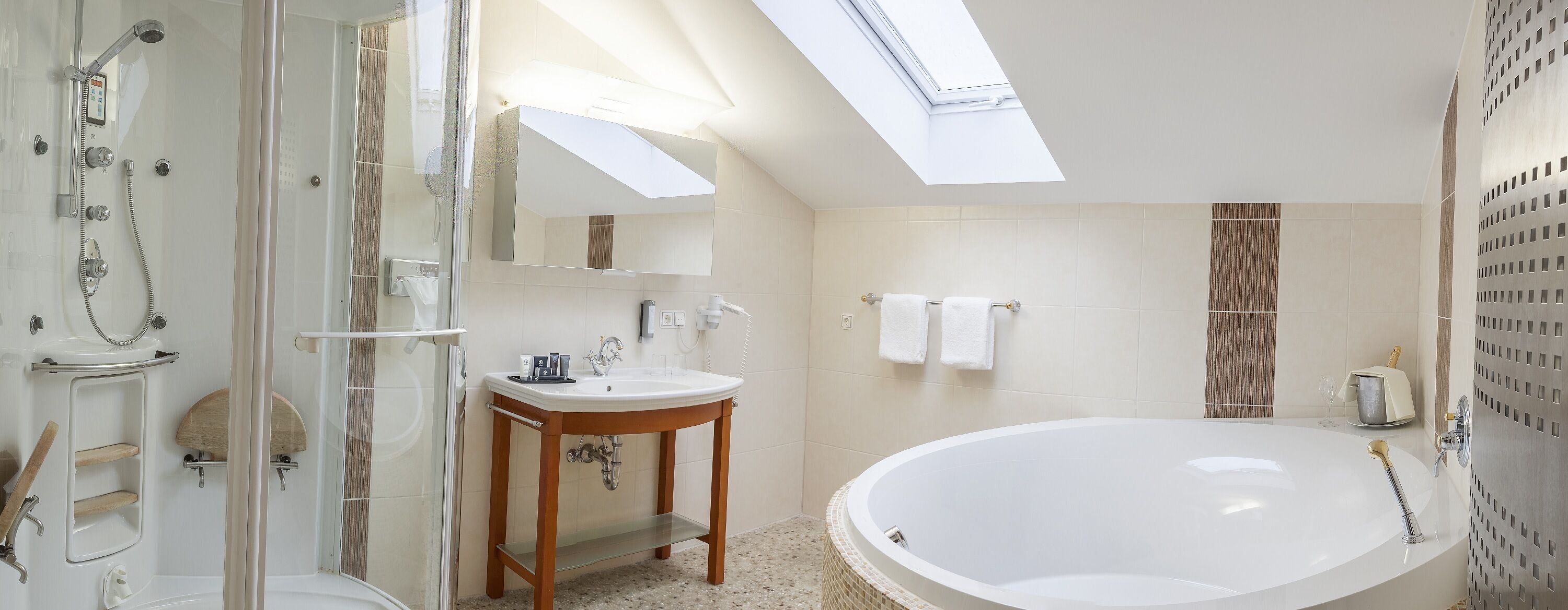 A modern bathroom with a glass-enclosed shower, a freestanding sink, and a large bathtub.