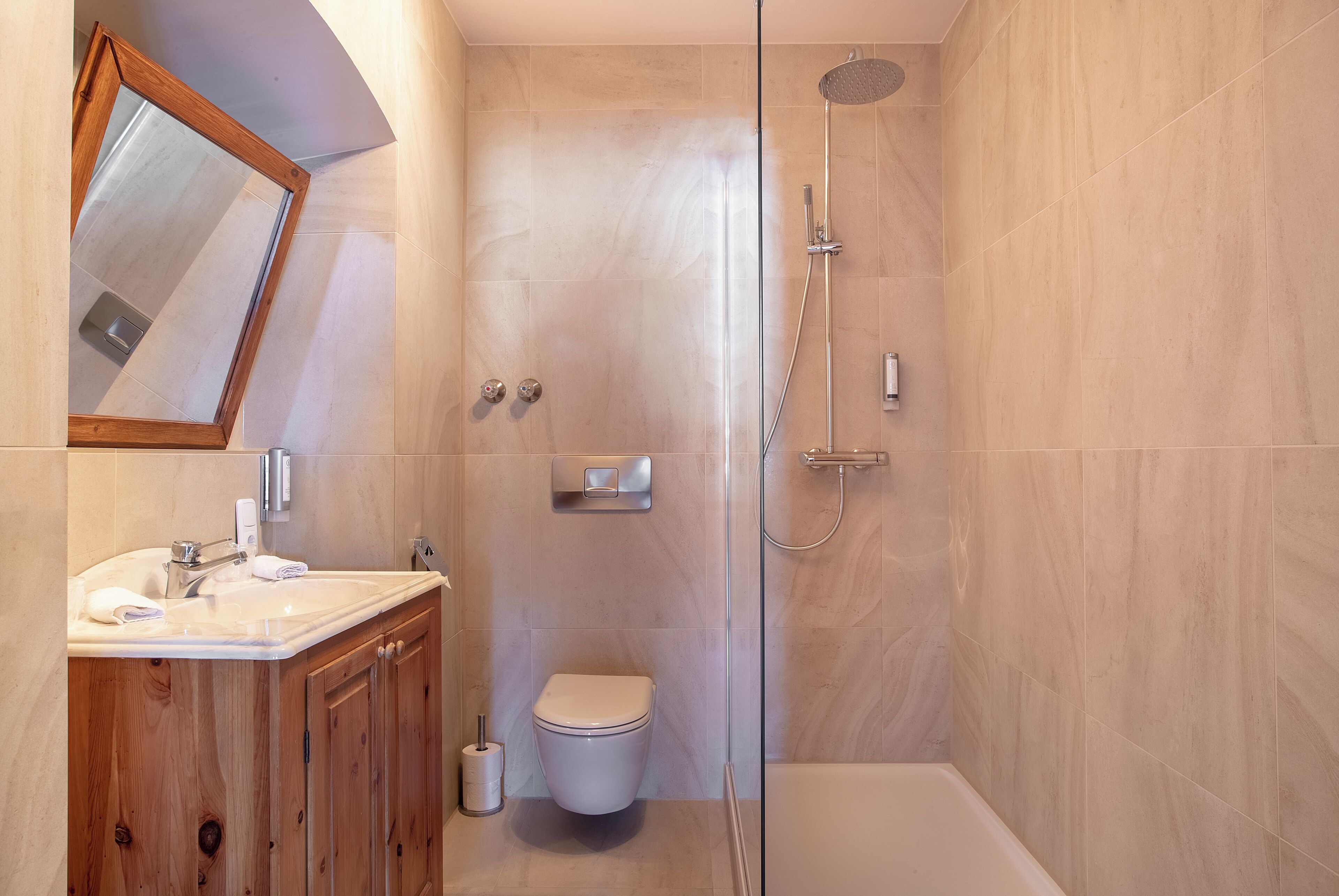 A modern bathroom with a toilet, sink, and shower.