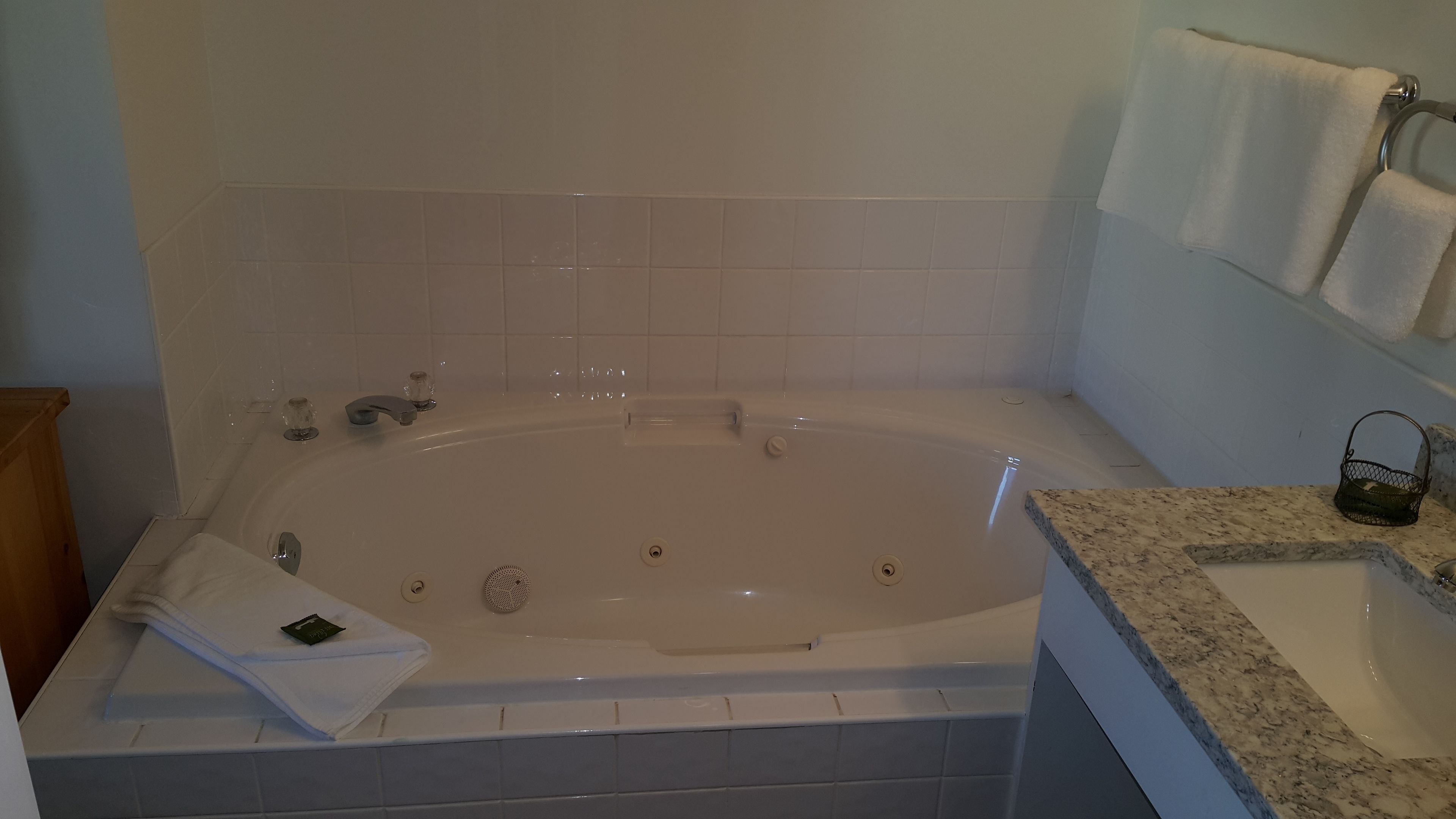 Une salle de bain avec une baignoire, un lavabo et un porte-serviettes.