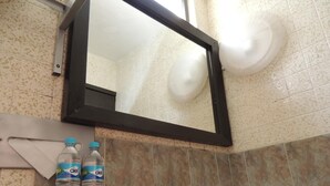 Un baño con un lavamanos, dos botellas de agua Ciel, una toalla y un espejo.