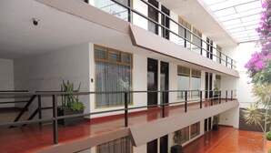 A multi-level building with balconies, large windows, and indoor plants. - Hotel Lizbeth (Tula de Allende)