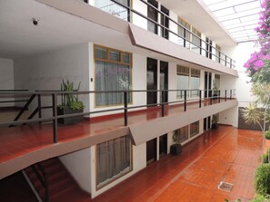 A multi-level building with balconies, large windows, and indoor plants. - Hotel Lizbeth (Tula de Allende)