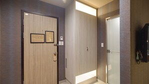 A hallway with wooden doors, a framed certificate, and a wall-mounted telephone. - East Dragon Hotel (Taipei)