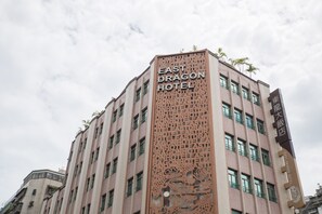 The East Dragon Hotel with a prominent vertical sign featuring the hotel's name.