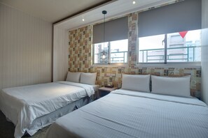 A hotel room with two beds, a window with a view, and a patterned wall.