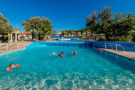 Una piscina al aire libre de temporada, sombrillas