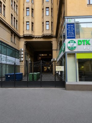 A building entrance with a gated driveway, a sign for a dental clinic, and a sign for a panic room. - Esprit Hotel Budapest (Budapest)