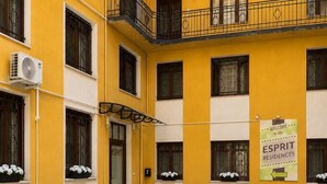 A yellow building with multiple balconies, air conditioning units, and a sign welcoming to the ESPIRIT residences. - Esprit Hotel Budapest (Budapest)