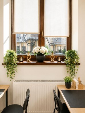 A room with a window, a radiator, a desk, two chairs, and a potted plant. - Esprit Hotel Budapest (Budapest)