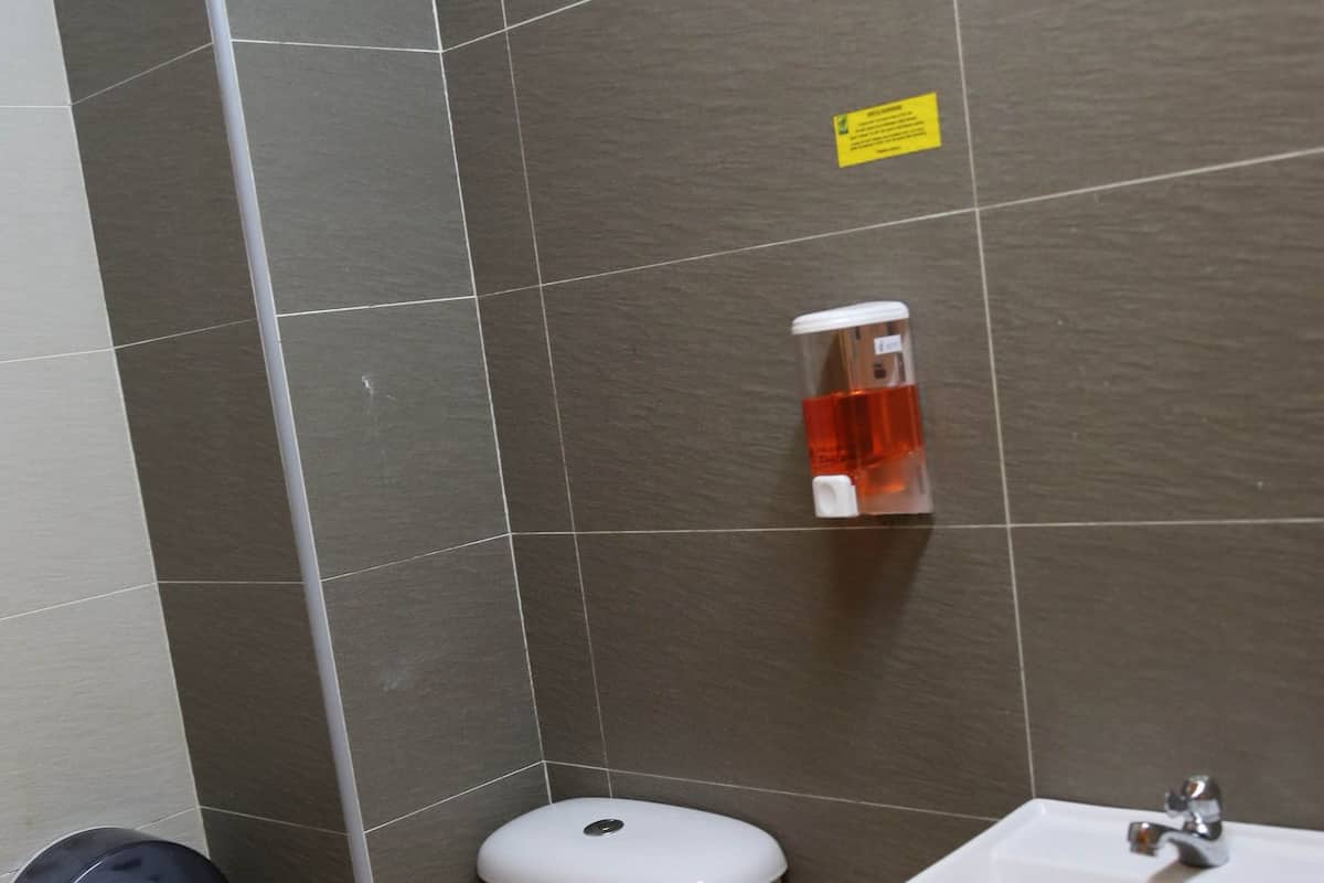 Une salle de bain équipée de toilettes, d’un lavabo et d’un sèche-mains.