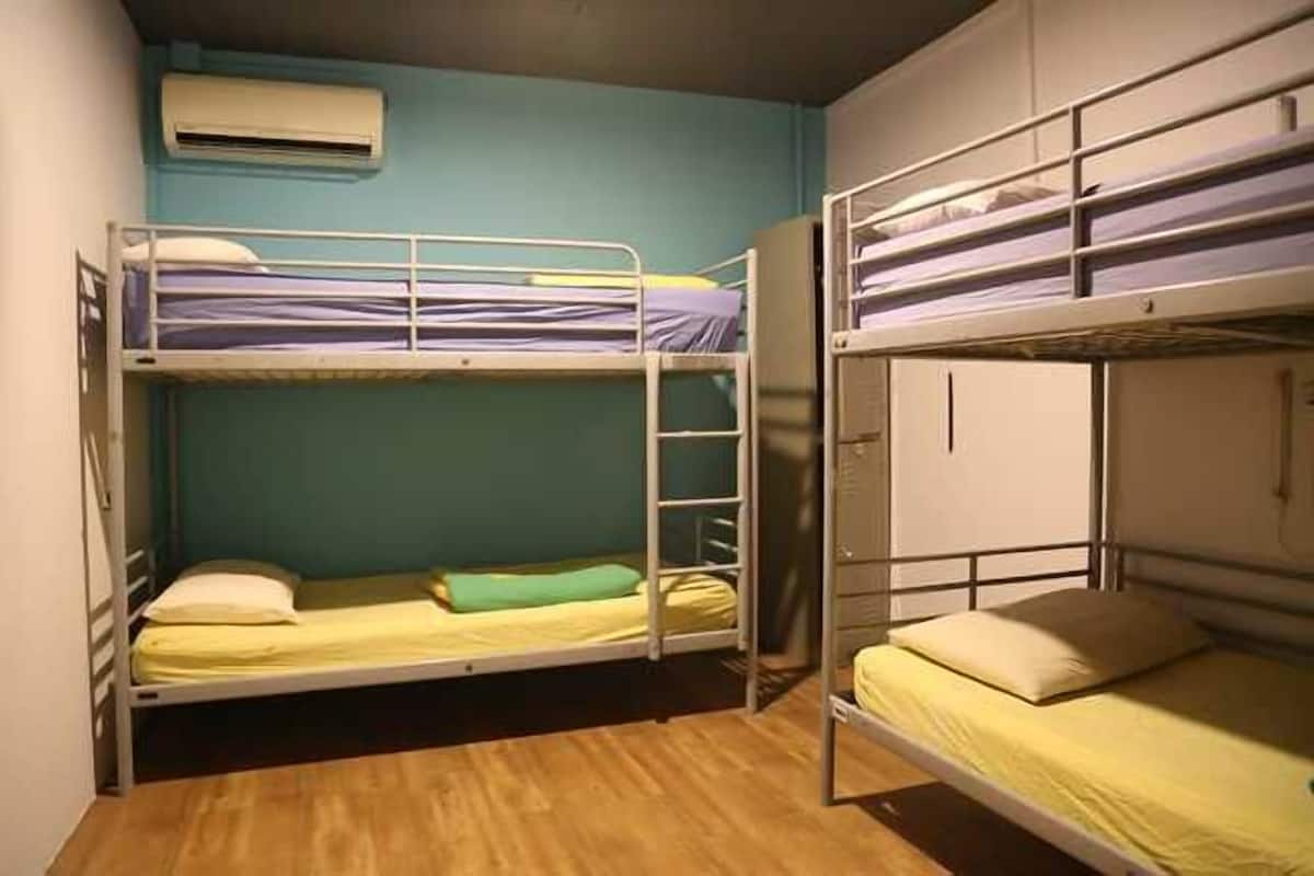 Une chambre de dortoir équipée de lits superposés, d’une armoire et d’un appareil de climatisation.