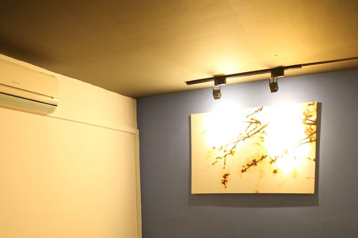Une chambre à coucher comprenant un lit, un climatiseur fixé au mur et un luminaire au plafond.