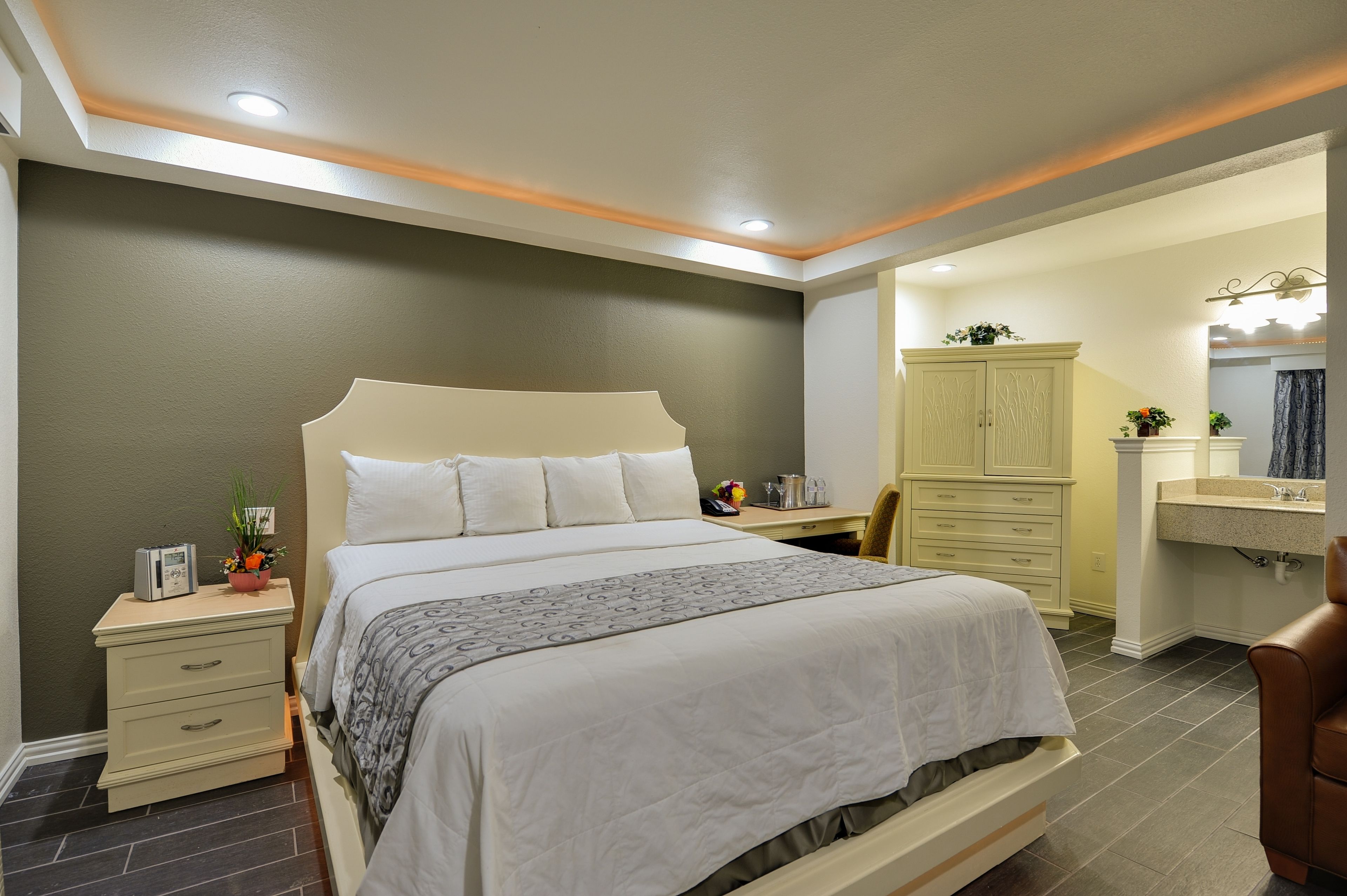 Un dormitorio con cama, mesita de noche, lámpara y armario.
