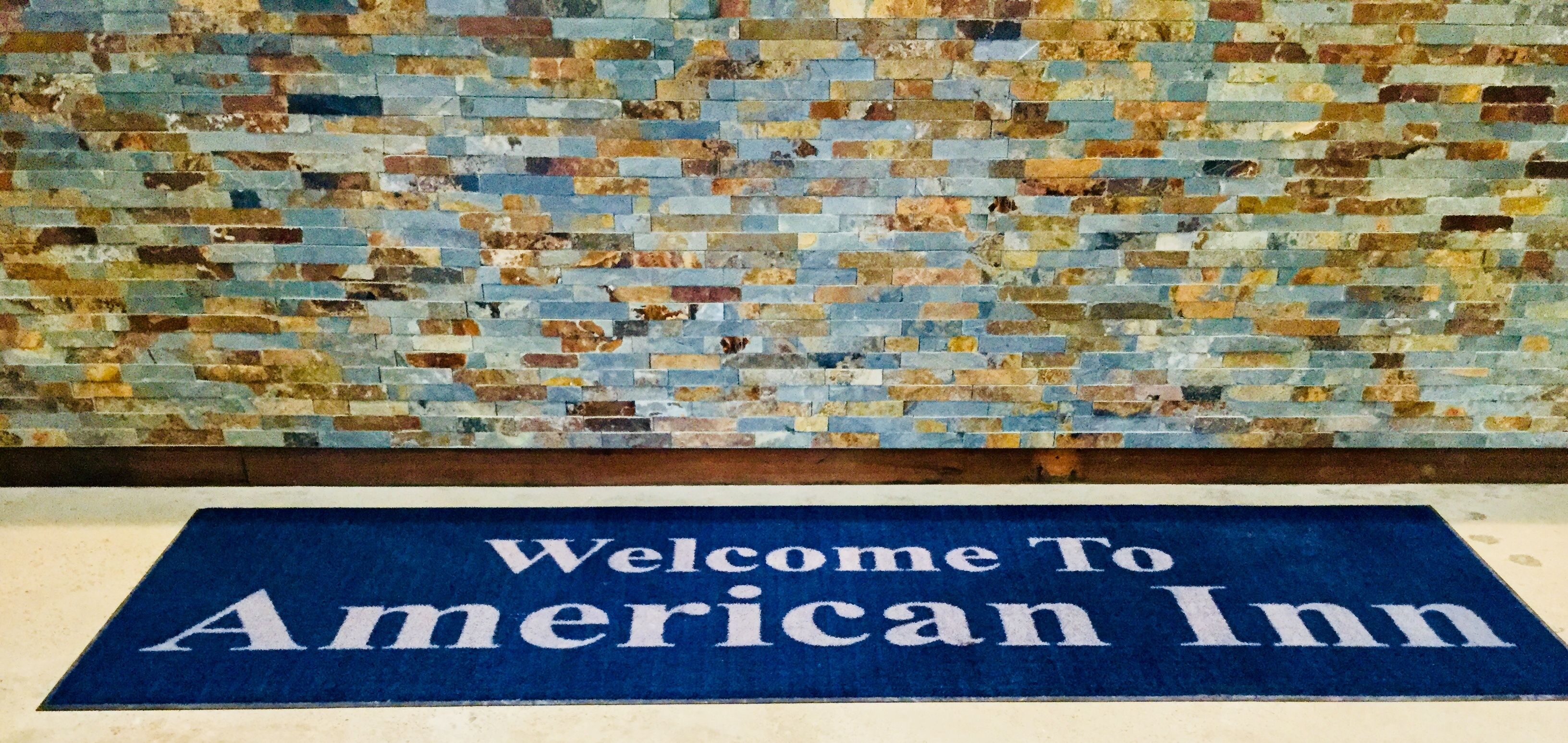 A welcome mat with "Welcome To American Inn" text.