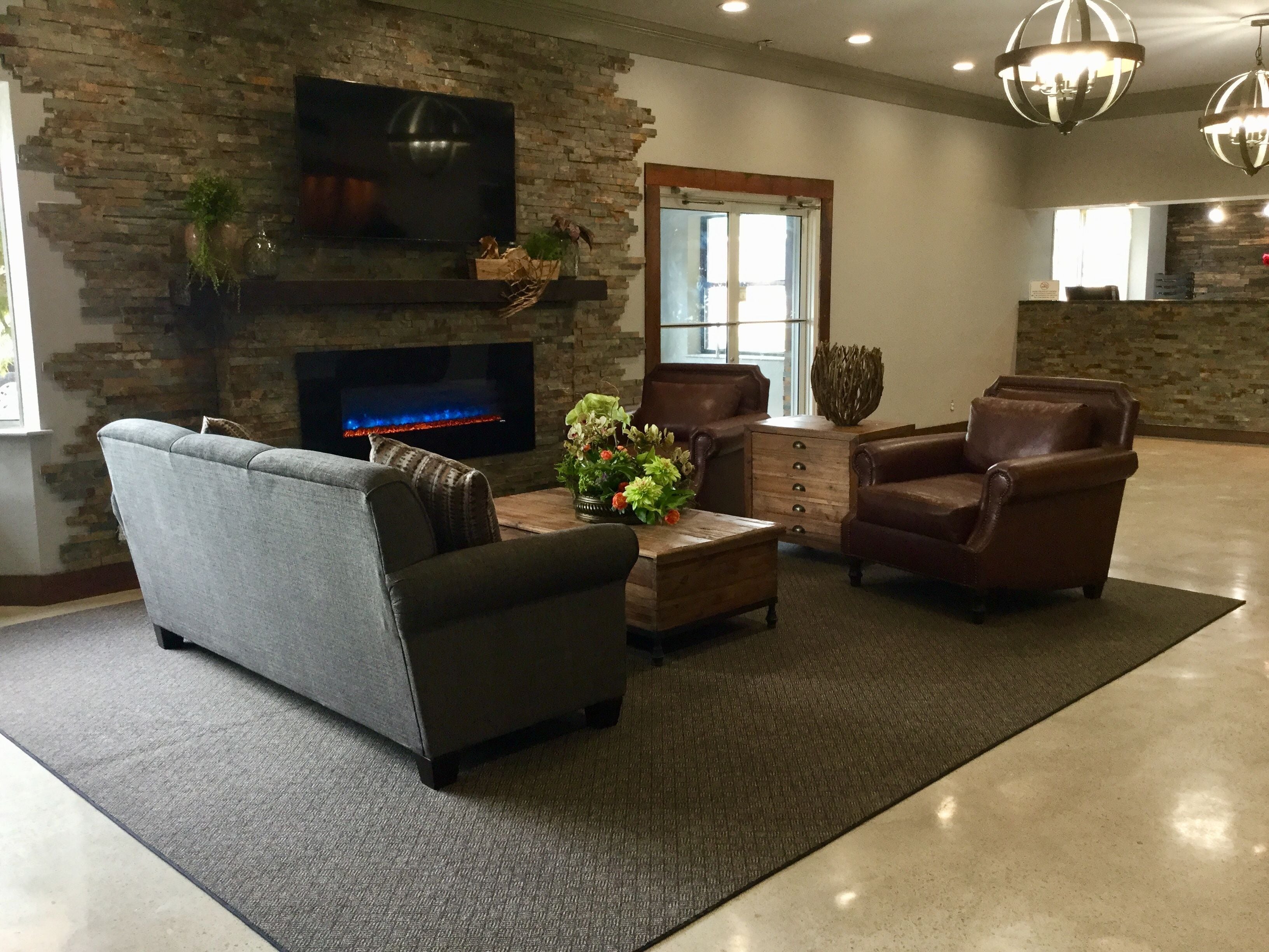 A living room with a fireplace, a television, and leather furniture.