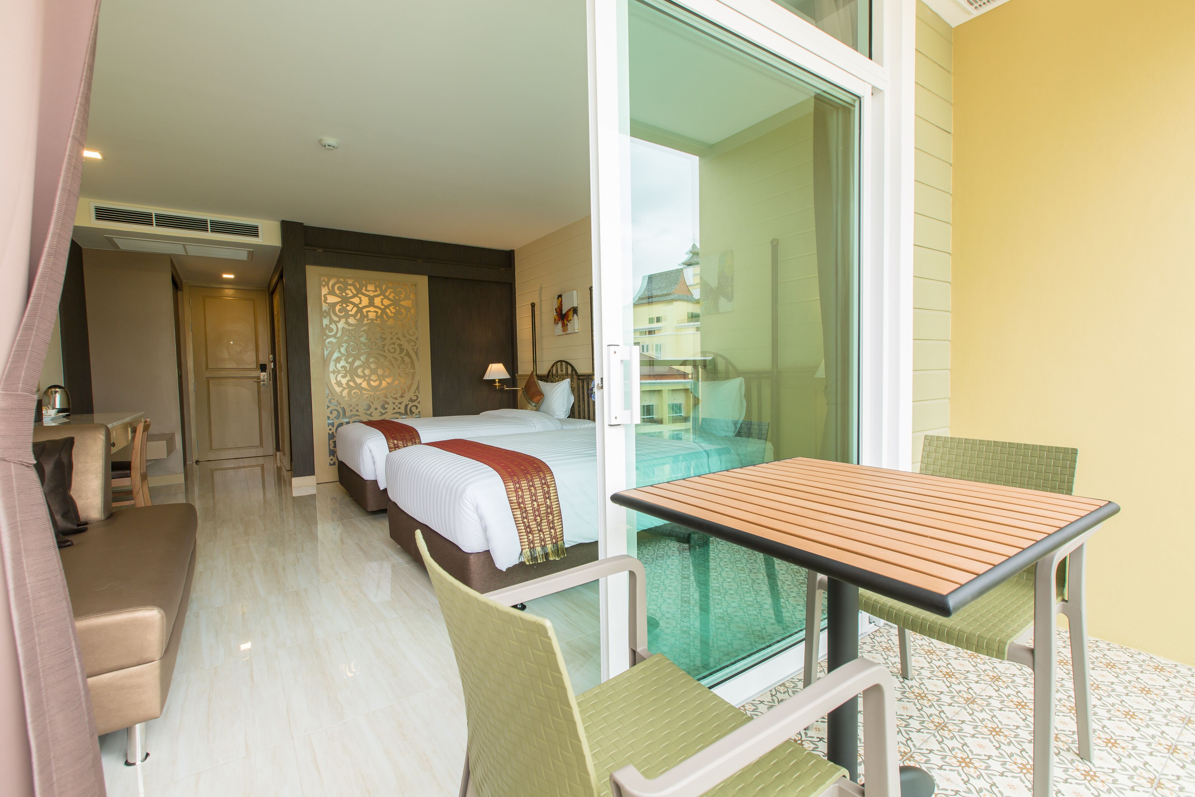 Habitació d'hotel amb balcó, llit, escriptori i cadira.