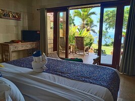 Una habitación de hotel con cama, escritorio, televisor y vistas al exterior.