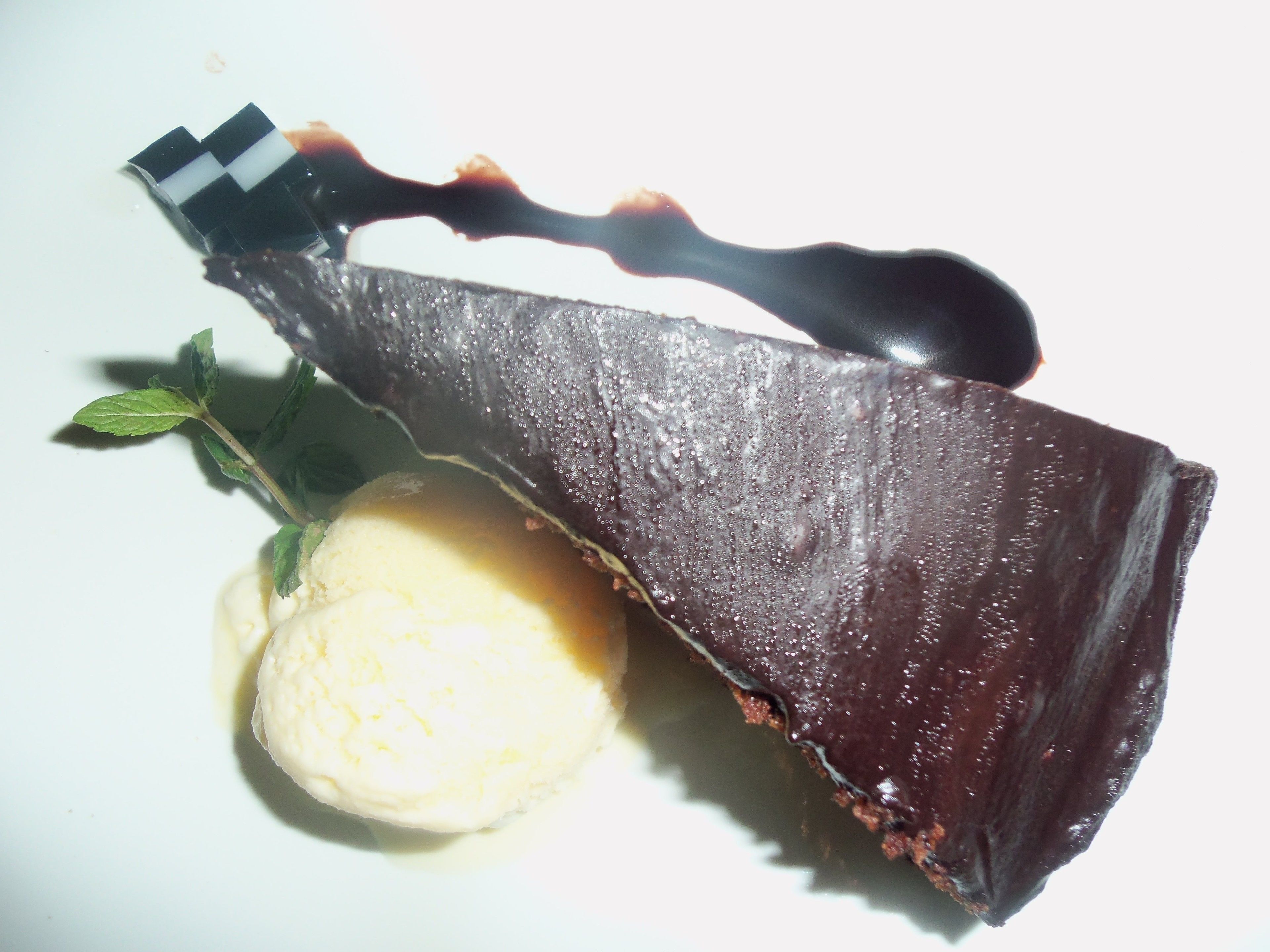 A dessert with a chocolate piece and a scoop of ice cream.