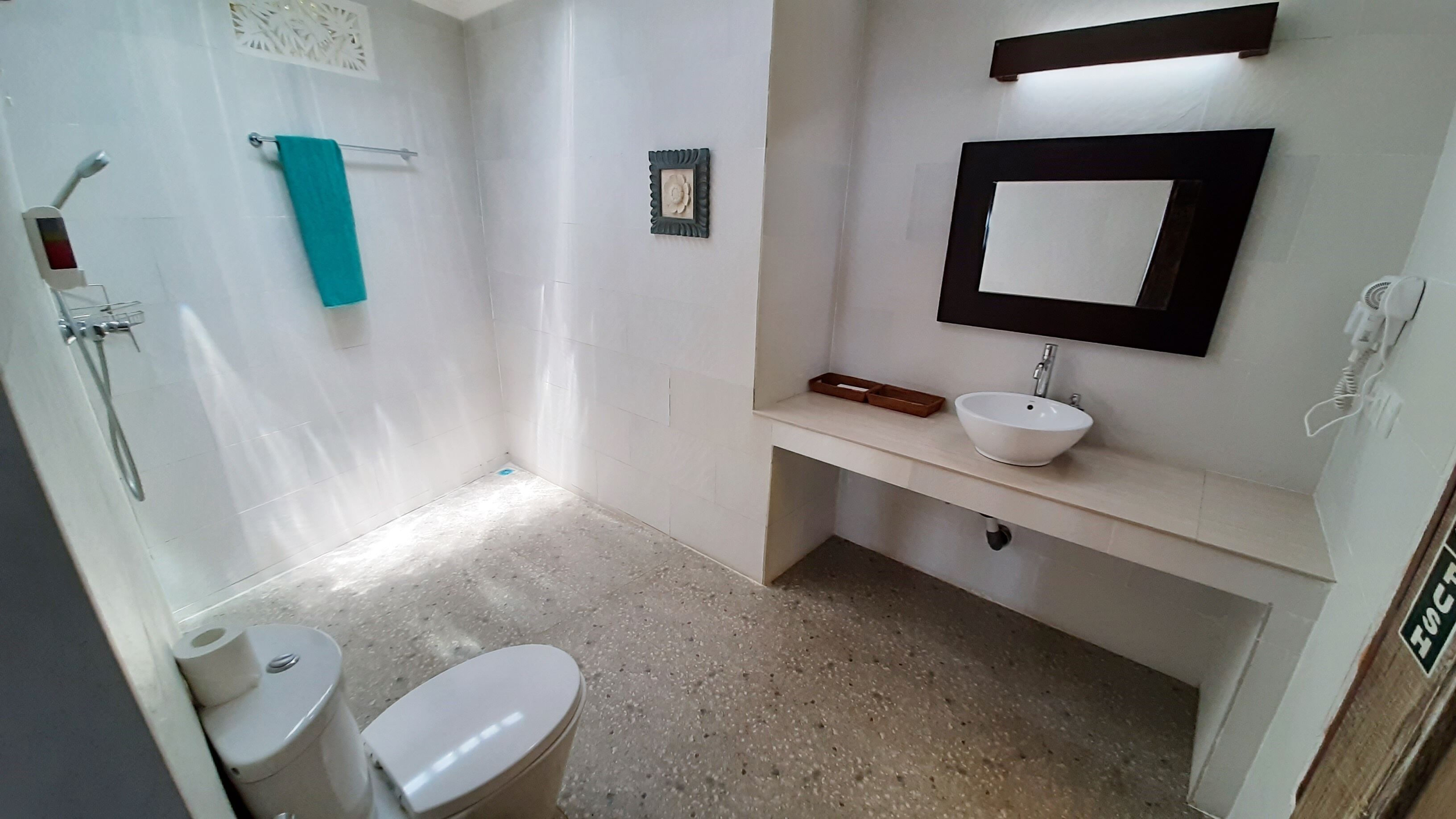 Un baño con inodoro, lavamanos y ducha.