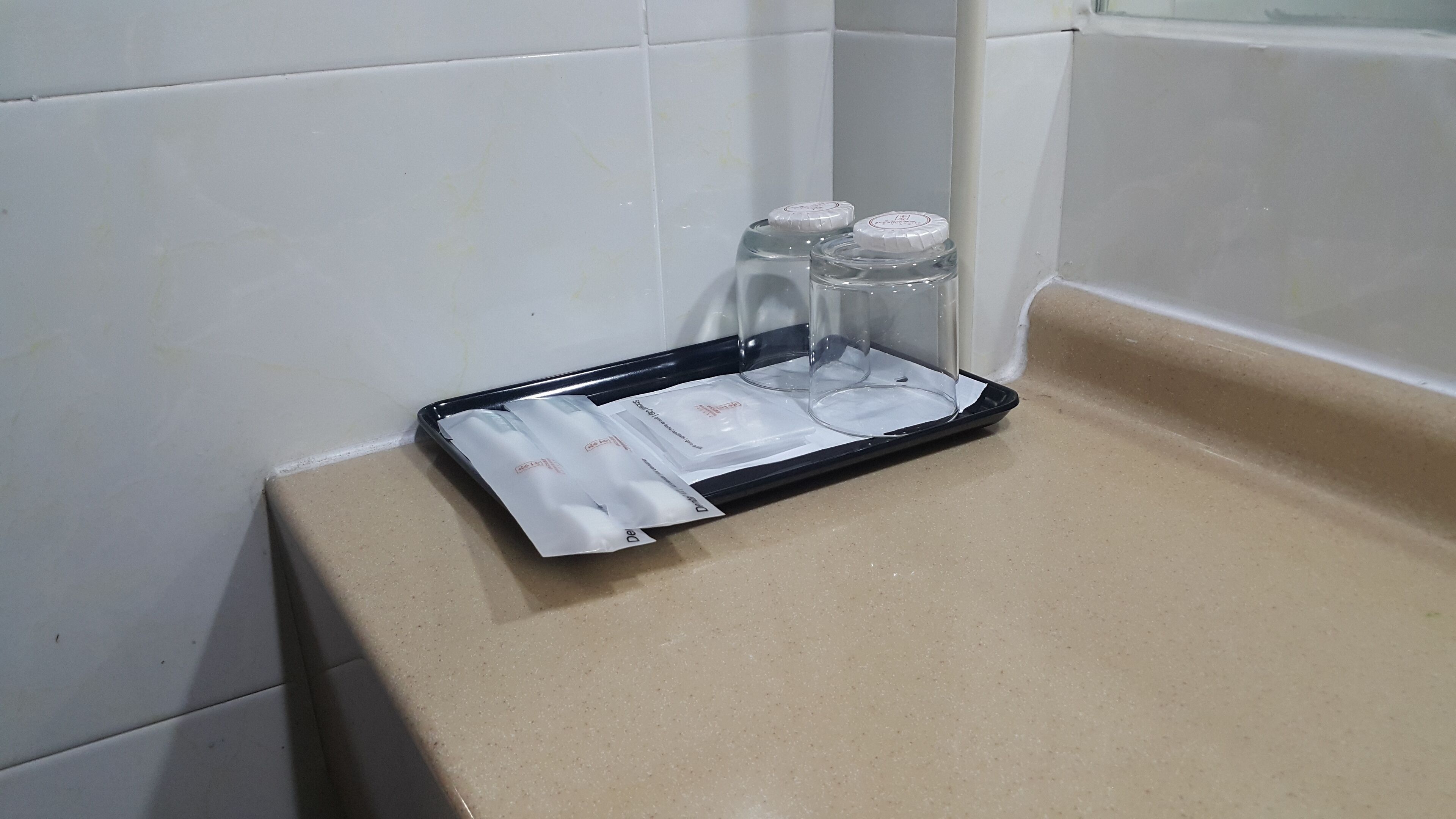 Una bandeja con cristalería y objetos sellados sobre una encimera.