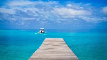 Perto da praia, areia branca, espreguiçadeiras, toalhas de praia