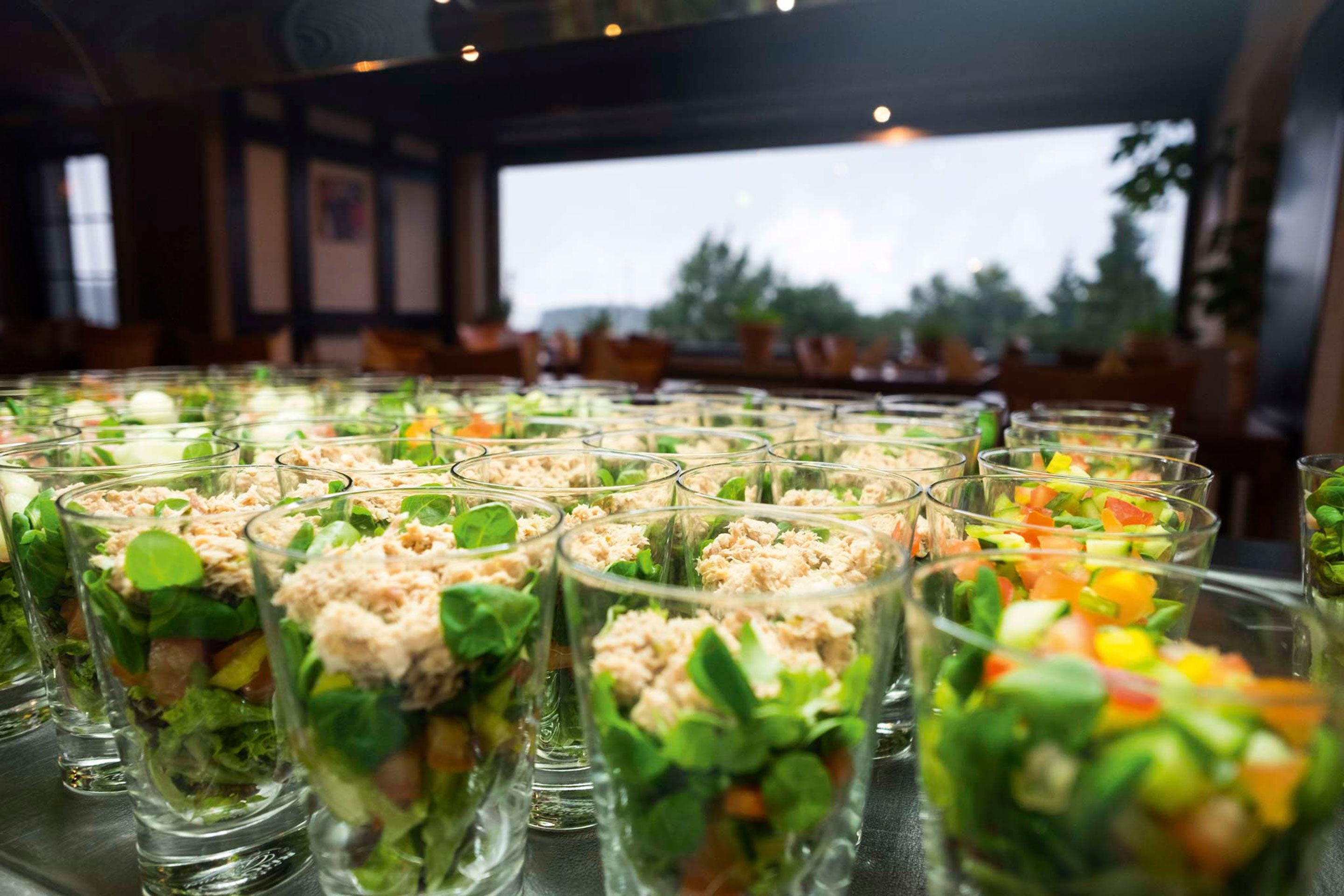 A buffet table with various glass dishes containing salads and other food items.