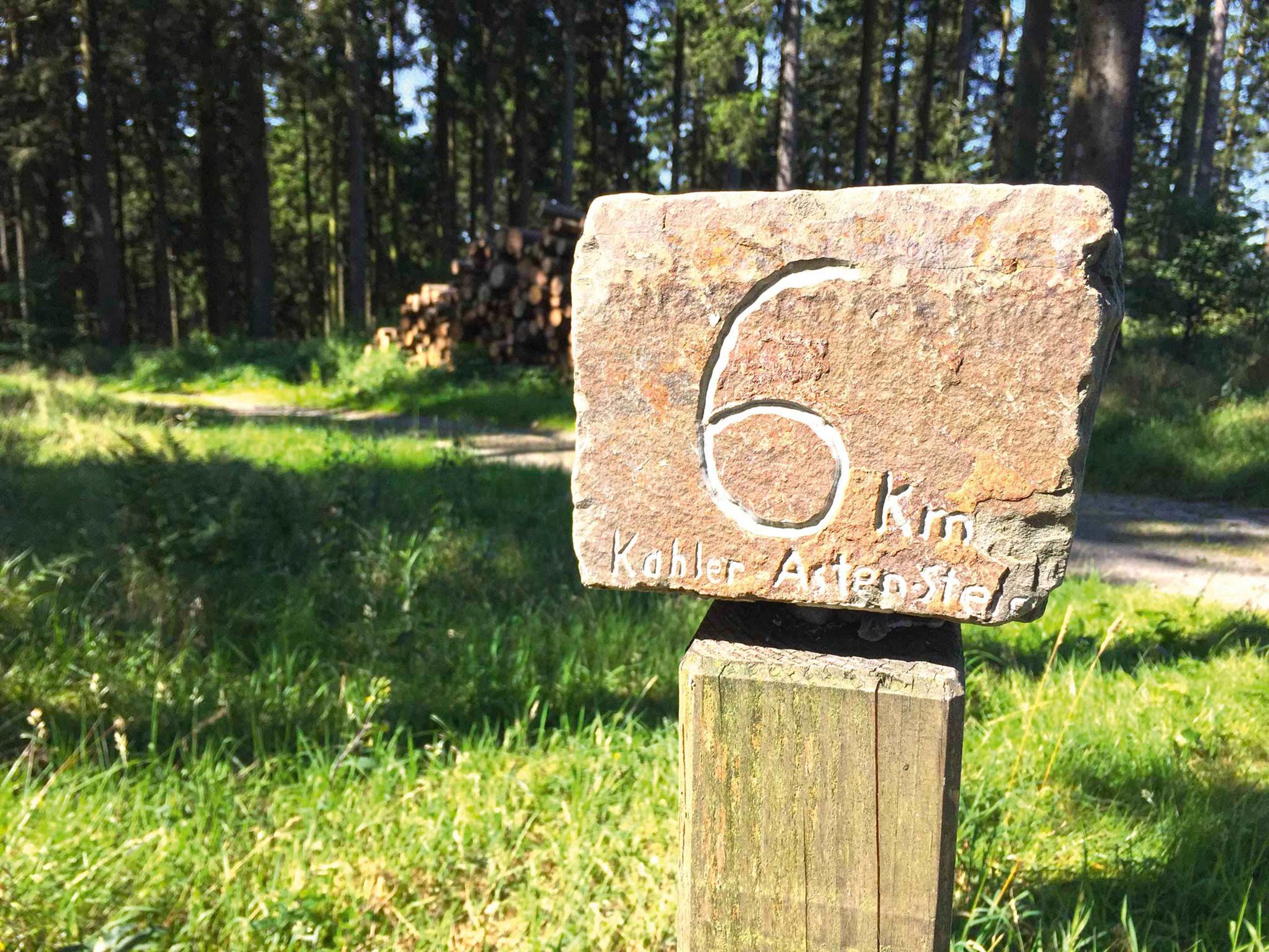 Kivestä tehty kyltti, jossa on numero 6 ja teksti »Kobler Alpenstrasse».