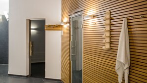 Une salle de bain moderne avec un mur recouvert de panneaux en bois, une douche en verre et un porte-serviettes.