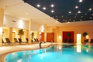 Una piscina techada, sillones reclinables de piscina