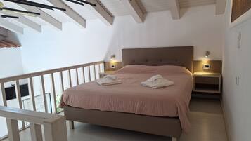 A bedroom with a bed, nightstands, and a balcony.