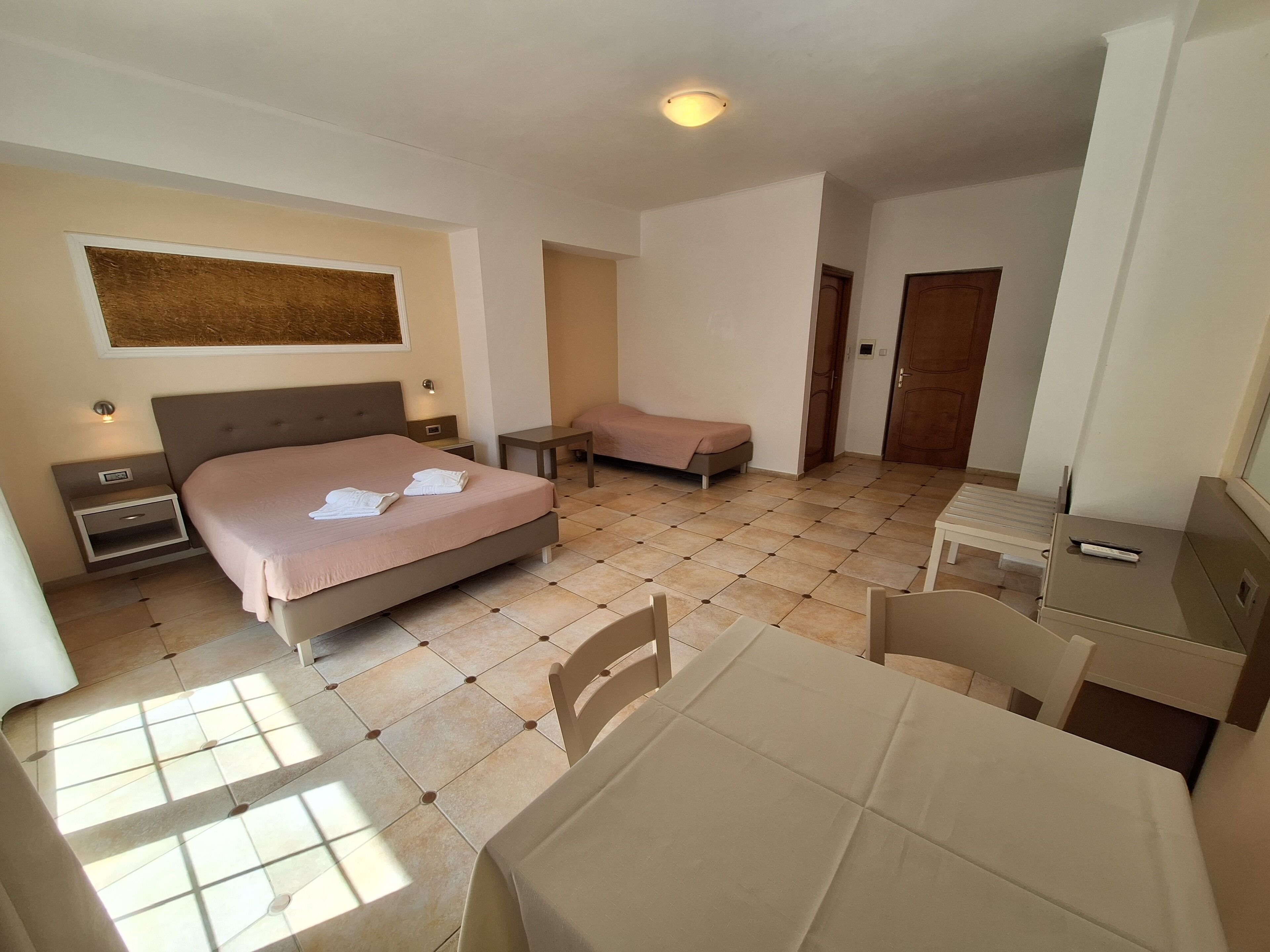 Une chambre d’hôtel comprenant un lit, une table de chevet, une chaise, un bureau et une petite table.