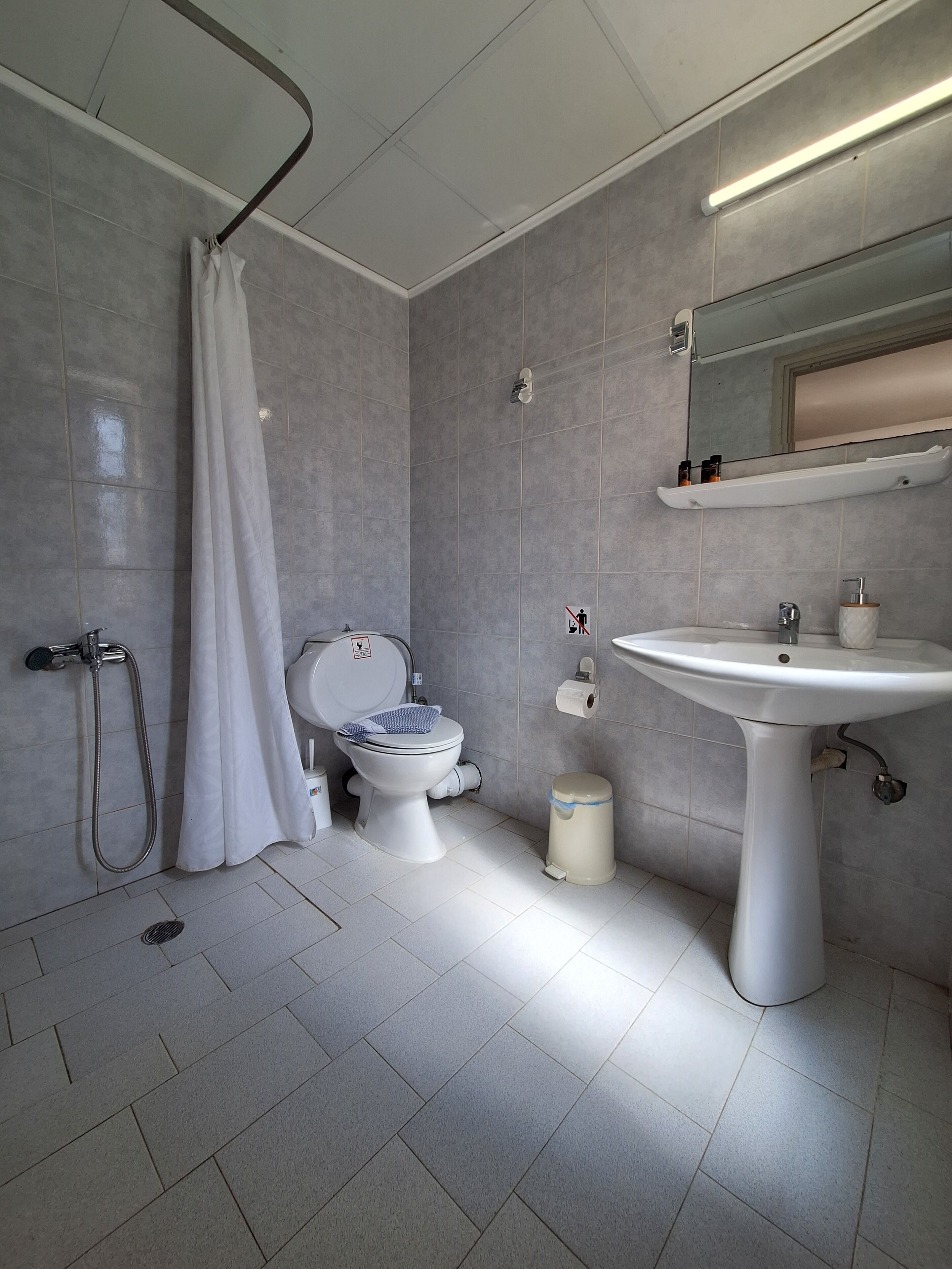 A modern bathroom with a toilet, shower, and sink.