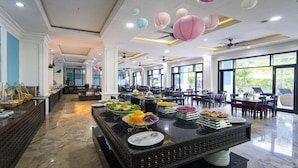 A buffet area with various food items and a seating area with tables and chairs. - Thanh Binh Riverside Hotel (Da Nang)