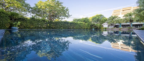Una piscina al aire libre, tumbonas