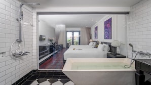 A modern hotel room with a large bed, a separate bathroom with a bathtub, and a view of the city through the window. - Thanh Binh Riverside Hotel (Da Nang)