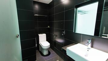 A modern bathroom with a white toilet, a sink, and a shower.