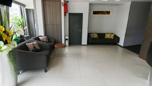 Een moderne woonkamer met een bank, een bijzettafeltje en een kamerplant.