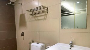A bathroom with a toilet, sink, and shower.