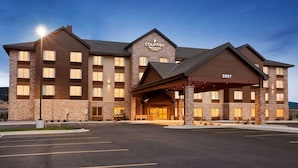 A multi-story hotel with a stone facade, a prominent entrance, and a parking lot.