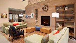 A modern living room with a fireplace, built-in shelves, and a large clock on the wall.
