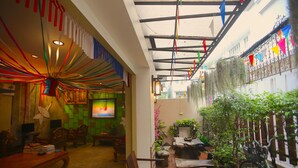 A cozy indoor space with a wooden table, chairs, and a television. - At Smile Oasis Houses (Bangkok)