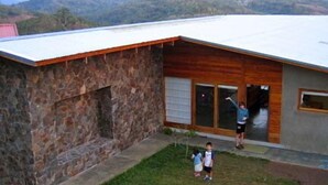A house with a stone exterior and a wooden front porch. - Casa Amanecer Bed & Breakfast (San Juan)