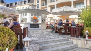 A hotel courtyard with outdoor seating, a fountain, and a signboard. - SEETELHOTEL Ostseeresidenz Heringsdorf (Heringsdorf)