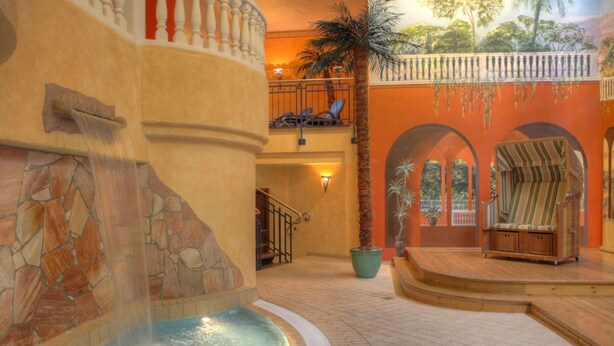 A spa area with a hot tub, a palm tree, and a lounge chair. - SEETELHOTEL Ostseeresidenz Heringsdorf (Heringsdorf)