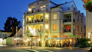 A multi-story hotel with outdoor seating and a sign for Biergarten. - SEETELHOTEL Ostseeresidenz Heringsdorf (Heringsdorf)