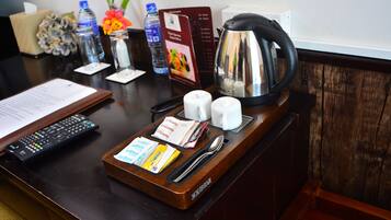 A hotel reception desk with a tray containing a remote control, a spoon, a knife, two salt shakers, a coffee pot, and a menu.