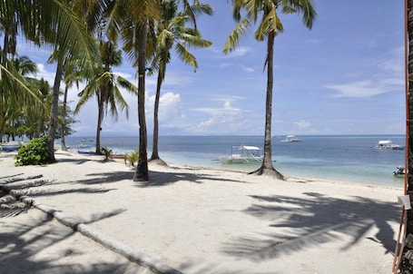 En la playa, arena blanca, sillas reclinables de playa, sombrillas